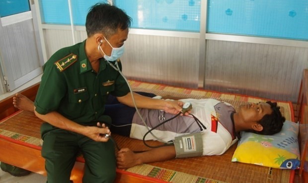 Un médecin militaire vérifie l'état de santé de la victime. Photo : VNA.