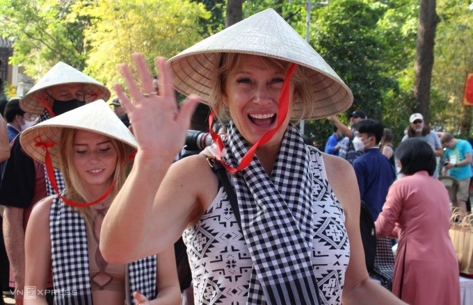 Les Américains portant des nón lá (chapeaux coniques vietnamiens) et khăn rằn (châles traditionnels à carreaux noir et blanc) à Ho Chi Minh-Ville, le 8 avril 2022. Photo de VnExpress .