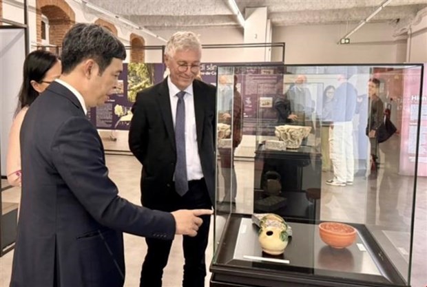 Nguyen Thanh Quang présente des reliques de la Citadelle impériale de Thang Long lors de l'exposition « Du sous-sol au musée : le voyage des artefacts » à Toulouse. Photo : VNA