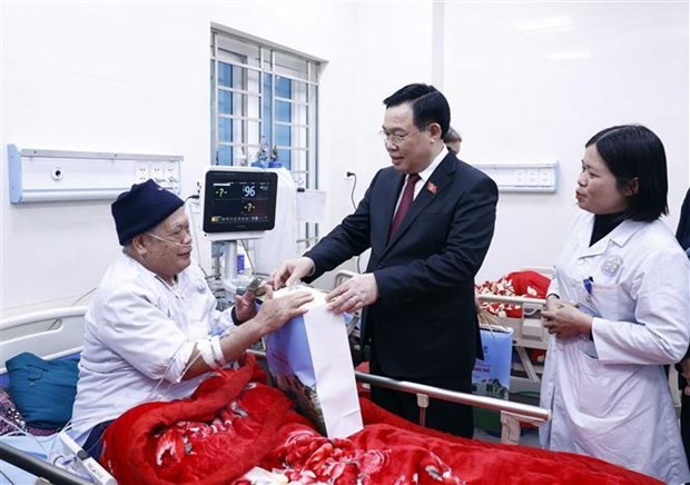 Le Président de l'Assemblée nationale Vuong Dinh Huê offre des cadeaux à un patient de la Polyclinique du district de Dinh Hoa. Photo : VNA.