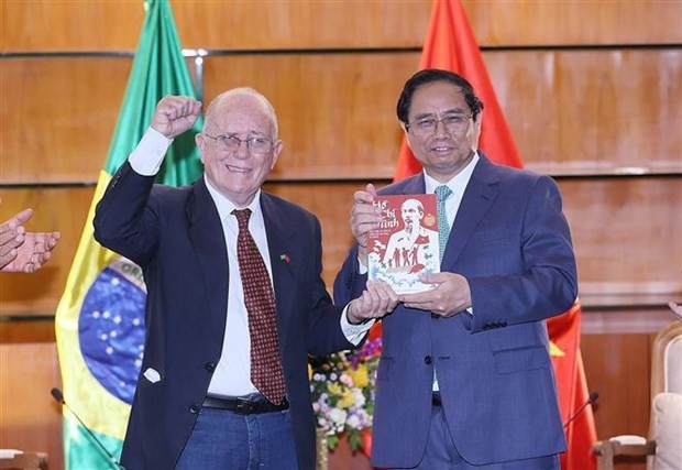 Le secrétaire général de l'Association d'Amitié Brésil - Vietnam, Pedro De Oliveira (à gauche) a offert son livre "Hô Chi Minh, la vie et l’œuvre du leader de la libération nationale du Vietnam" au Premier minsitre vietnamien Pham Minh Chinh. Photo : VNA.