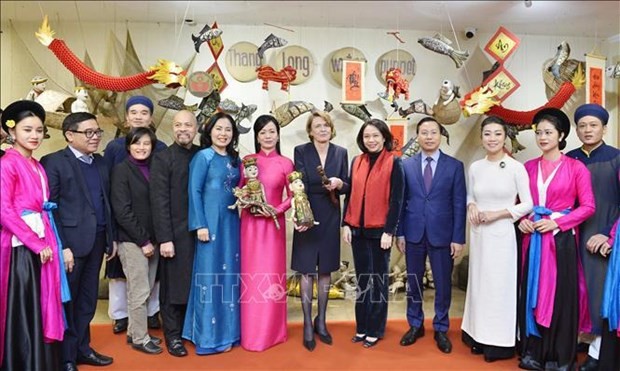 Les épouses des Présidents vietnamien et allemand prennent une photo avec des artistes du Théâtre de marionnettes Thang Long. Photo : VNA.