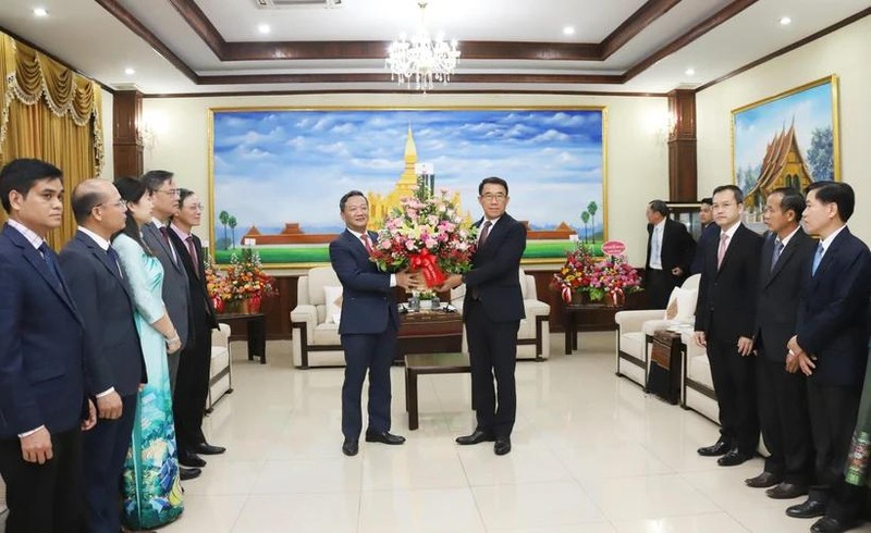 L'ambassadeur du Vietnam au Laos Nguyen Minh Tam remet des fleurs de félicitations du secrétaire général To Lam à la partie lao. Photo: VNA.