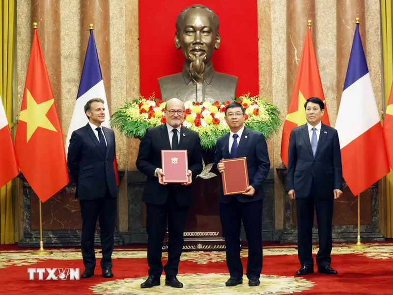 Cérémonie de remise du contrat de crédit pour le projet de renforcement du réseau de transport d’électricité dans le Sud du Vietnam, signé entre l’AFD et EVNNPT, en présence du président français et du président vietnamien. Photo : VNA.
