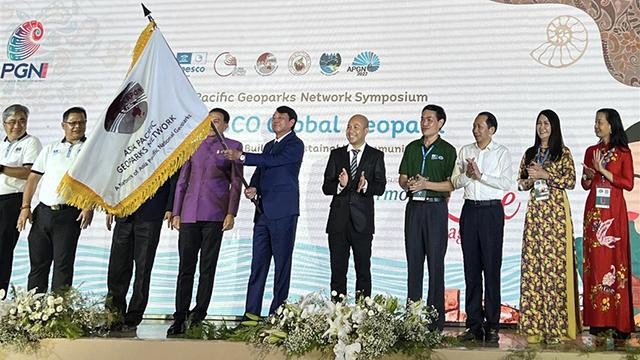 Le président du Comité populaire de la province de Cao Bang, Hoàng Xuân Anh, reçoit le drapeau pour accueillir alternativement la 8e Conférence internationale du Réseau régional des géoparcs mondiaux UNESCO de la région Asie-Pacifique en 2024. Photo : thoidai.com.vn