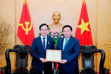 Le membre du Politburo, président de l’Académie nationale de politique Hô Chi Minh (HCMA) et président du Conseil théorique central, Nguyên Xuân Thang (à droite) décerne l'Insigne de l'HCMA «Pour la cause de l'éducation et de la formation en théorie politique» au directeur général de Samsung Vietnam, Choi Joo Ho. Photo : VNA