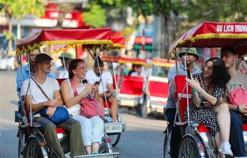 Des touristes étrangers prennent un cyclo-pousse pour découvrir le Vieux quartier de Hanoi. Photo : VNA.