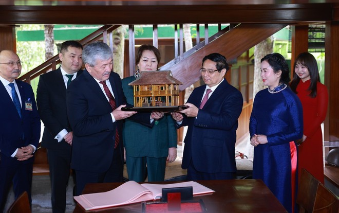 Le Premier ministre Pham Minh Chinh offre son homologue kirghize Adylbek Kasimaliev la maison sur pilotis miniature. Photo : VNA.