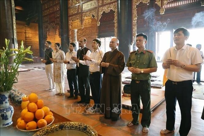 Des délégués offrent des baguettes d'encens à la pagode Tam Chuc. Photo : VNA.