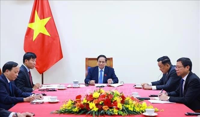 Le Premier ministre Pham Minh Chinh (au centre) s’entretient par téléphone avec le secrétaire général du PAP et Premier ministre singapourien Lawrence Wong. Photo : VNA.