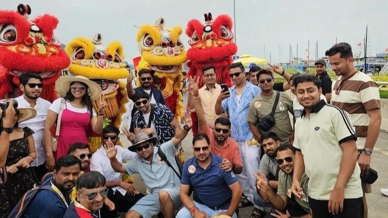 Des touristes indiens prennent des photos souvenirs avant d'embarquer sur un bateau pour visiter la baie d'Ha Long. Photo : NDEL.