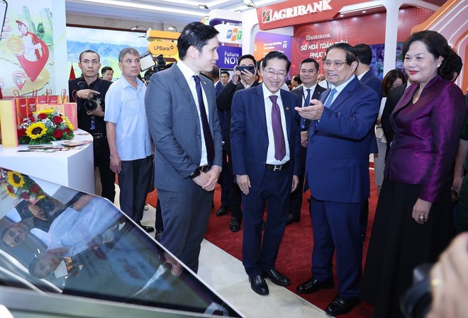 Le Premier ministre Pham Minh Chinh visite l'exposition de produits, services et applications de transformation numérique pour les activités bancaires. Photo : VNA.