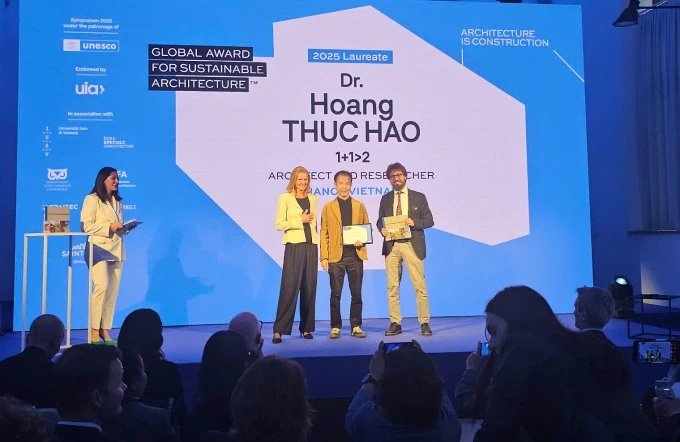 L'architecte Hoang Thuc Hao (au centre) recevant le Prix Mondial de l'Architecture Durable 2025. Photo : Vnexpress.