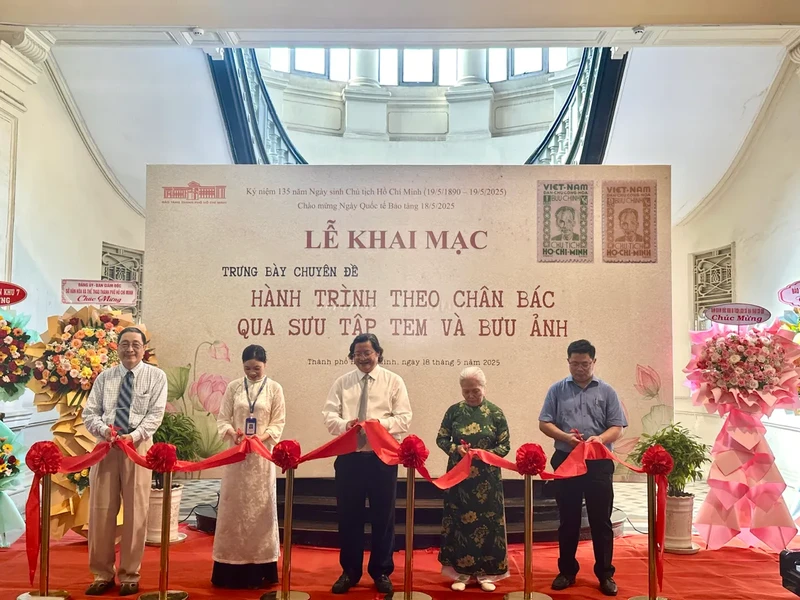 Des délégués coupent le ruban inaugural de l'exposition thématique "Sur les traces de l'Oncle Hô à travers une collection de timbres et de cartes postales". 