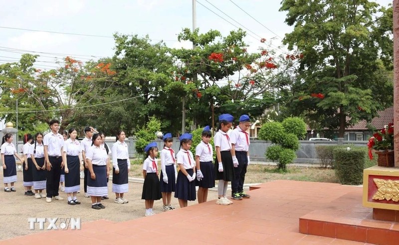 Des élèves de l’École d’amitié Laos-Vietnam de Savannakhet déposent des fleurs au site historique dédié au président Ho Chi Minh. Photo : BQT.