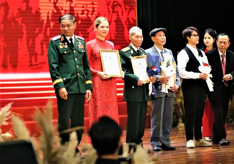 Aleksandra en ao dai rouge lors du programme artistique « L'écho de la marche militaire ». Photo fournie par le personnage.