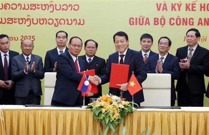 Le ministre vietnamien de la Sécurité publique, Luong Tam Quang (à droite, premier plan), et le vice-Premier ministre lao et ministre de la Sécurité publique, Vilay Lakhamphong se serrent la main, à Hanoi, le 12 janvier. Photo: VNA