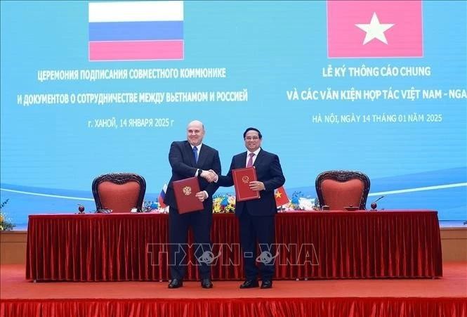 Les deux Premiers ministres vietnamien (à droite) et russe signent un communiqué conjoint. Photo : VNA.