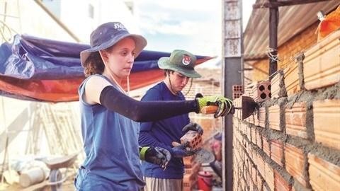 Deux jeunes Américains posent des briques dans la province de Quang Ngai, au Centre. Photo : CVN.