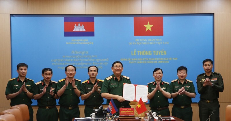 Le général de corps d'armée Huynh Chien Thang, chef adjoint de l'état-major général de l'Armée populaire du Vietnam signe un document sur l'ouverture d'une ligne téléphonique directe entre l'État-major général de l'Armée populaire du Vietnam et le commandement général des forces armées royales du Cambodge. Photo : VNA.