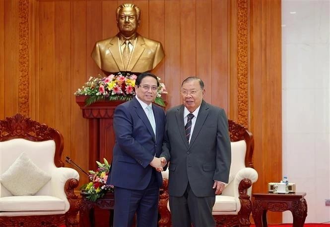 Le Premier ministre Pham Minh Chinh (à gauche) rencontre l'ancien secrétaire général du Parti et ancien président du Laos Bounnhang Vorachit. Photo : VNA. 