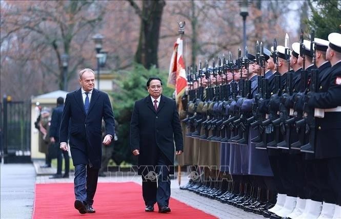 Le Premier ministre vietnamien Pham Minh Chinh (à droite) et son homologue polonais Donald Tusk inspectent la garde d’honneur, à Varsovie, le 16 janvier. Photo: VNA 