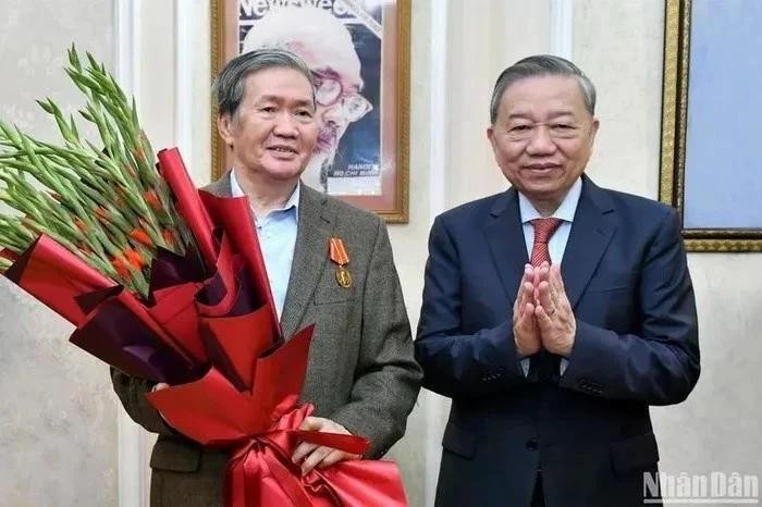 Le secrétaire général du Parti communiste du Vietnam Tô Lâm (droite) félicite Dinh Thê Huynh. 