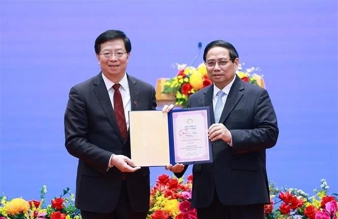 Le professeur et docteur Qiu Yong (gauche) remet le titre de « professeur honoraire » de l'Université Tsinghua au Premier ministre Pham Minh Chinh (à droite). Photo : VNA 