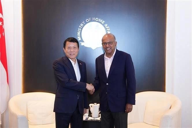 Le ministre vietnamien de la Sécurité publique Luong Tam Quang (à gauche) et le ministre singapourien de l’Intérieur, K. Shanmugam se serrent la main, à Singapour, le 13 mars. Photo : VNA. 