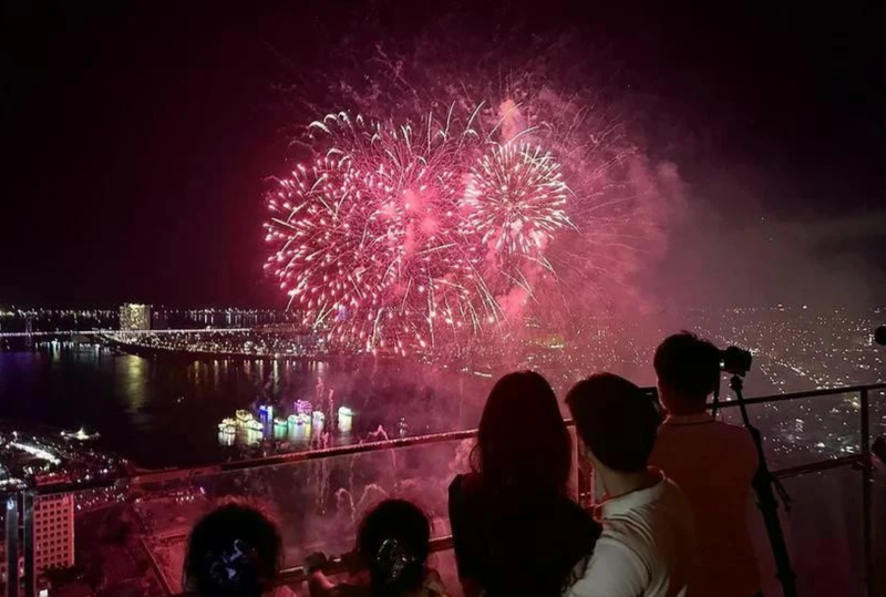 Des touristes regardent un feu d’artifice dans la ville de Dà Nang. Photo : VNA.