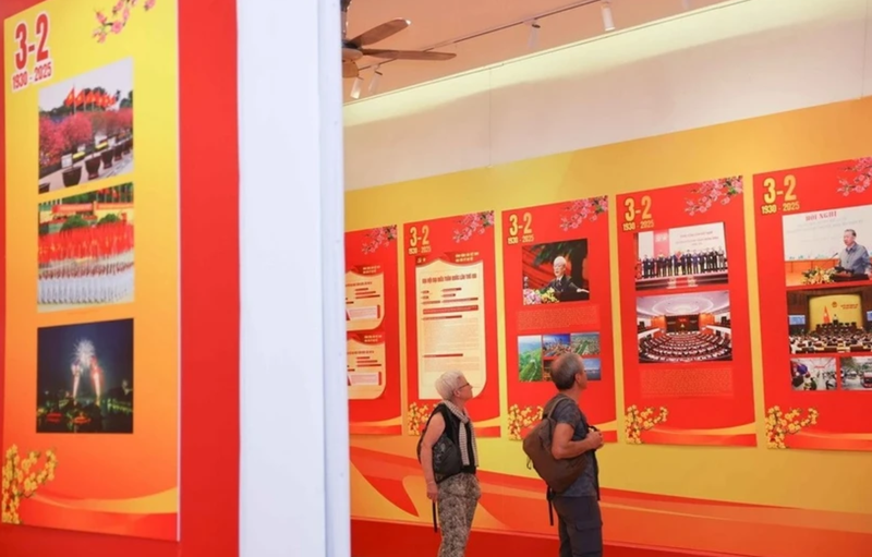 Des visiteurs internationaux visitent une exposition sur le Parti à Hanoi à l'occasion du 95e anniversaire de la fondation du Parti communiste du Vietnam. Photo : VNA.