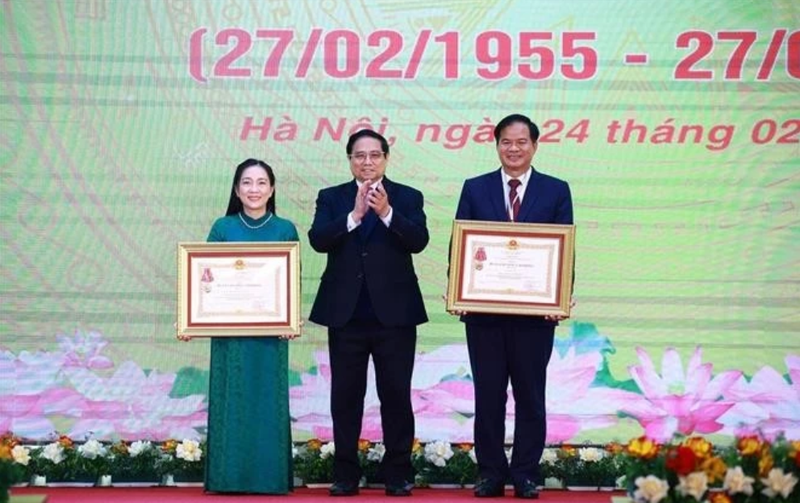 Le Premier ministre Pham Minh Chinh (au centre) remet l’Ordre du travail de troisième classe au professeur associé Dr Dào Xuân Co, directeur de l’Hôpital Bach Mai, et le titre de docteure émérite à Nguyên Thi Mai Ngoc, à l’Institut national de cardiologie du Vietnam relevant de l’Hôpital Bach Mai. Photo : VNA.