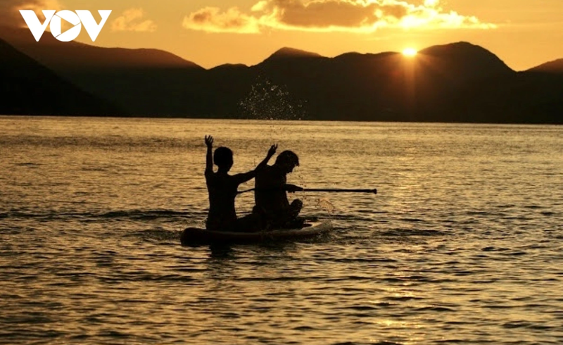 Des touristes rament sur la mer de Con Dao lors du coucher du soleil. Photo : VOV