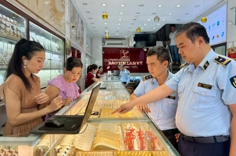 Inspecteurs du marché lors d'un contrôle de routine dans un magasin d'or de l'arrondissement de Cầu Giấy, Hà Nội. Photo : VNA. 