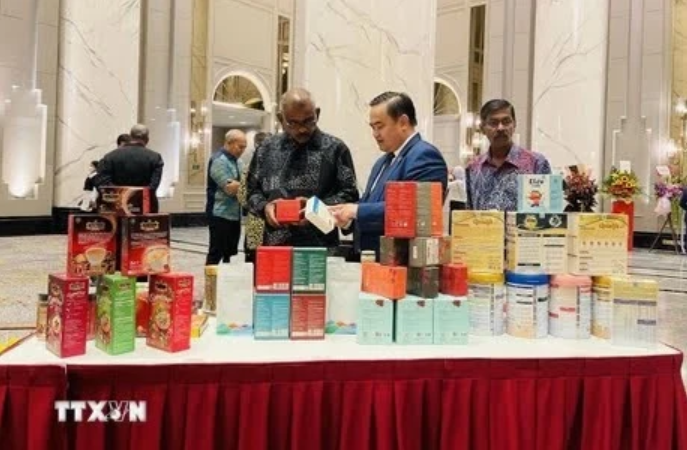 Le Phu Cuong (au milieu), conseiller commercial vietnamien en Malaisie, présente des produits vietnamiens lors d'une foire en Malaisie. Photo : VNA.