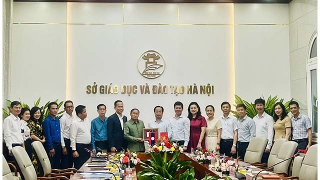 Le dirigeant du Service de l'Éducation et de la Formation de Hanoi présente un cadeau de souvenirs à la délégation du Service de l'Éducation et des Sports de la province de Champassak. Photo : kinhtedothi.vn