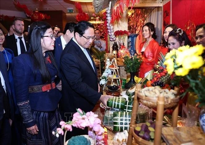 Le Premier ministre Pham Minh Chinh et son épouse visitent un stand du Têt de la communauté vietnamienne lors de l'événement. Photo : VNA.