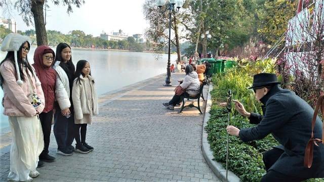 Une famille de trois générations se promène ensemble pour capturer des images joyeuses le premier jour du Nouvel An lunaire. Photo : Quang Tuan/NDEL.