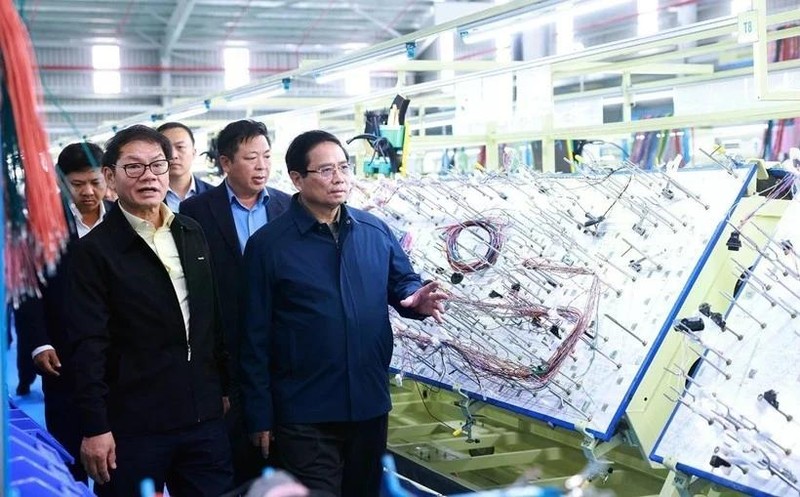 Le Premier ministre Pham Minh Chinh visite une chaîne de production d'une entreprise à Quang Nam. Photo : VNA. 