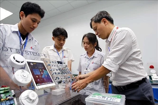 Un professeur de l'Université d'Industrie de Ho Chi Minh-Ville enseigne à des étudiants au laboratoire IoT et IA. Photo : VNA 