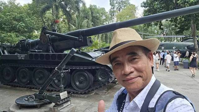 Le journaliste Huy Thang pose pour une photo souvenir avec des objets de guerre. Photo fournie par le personnage 