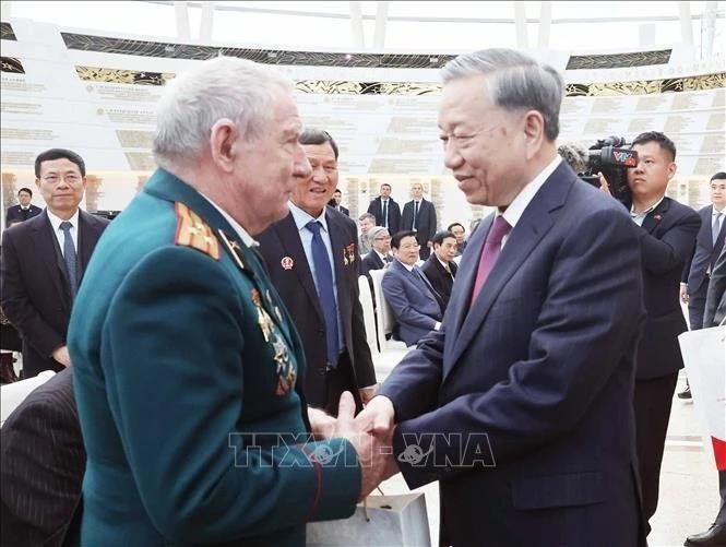 Le secrétaire général To Lam (droite) rencontre et offre des cadeaux aux vétérans biélorusses qui ont apporté des contributions exceptionnelles au Vietnam. Photo : VNA