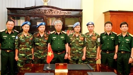 Le général de corps d'armée Nguyên Chi Vinh prend la photo de souvenir avec les officiers s’apprêtant à servir la Mission de maintien de la paix de l'ONU. Photo: QDND.