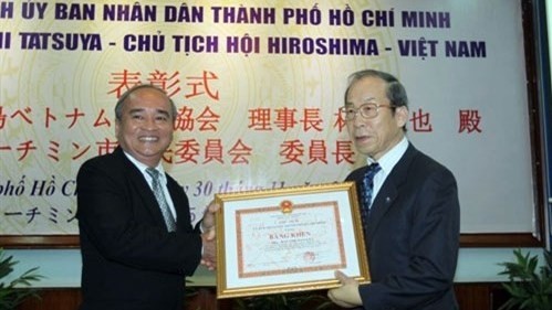 Le président de l’​Association Hiroshima - Vietnam, Tatsuya Hayashi (à droite), reçoit le certificat de mérite du Comité populaire de Hô Chi Minh-Ville. Photo: QDND.