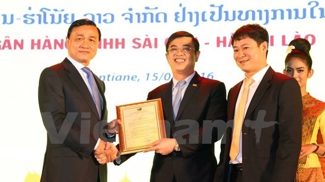 Le gouverneur de la Banque centrale du Laos, Somphao Phaysit, remet la décision de création de la Banque de SHB au Laos à Nguyên Van Lê, directeur général de la banque SHB. Photo: VNA.