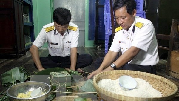 Des soldats de la charpente métallique DK1 font le «banh chung» pour accueillir le Têt traditionnel. Photo: VNA.