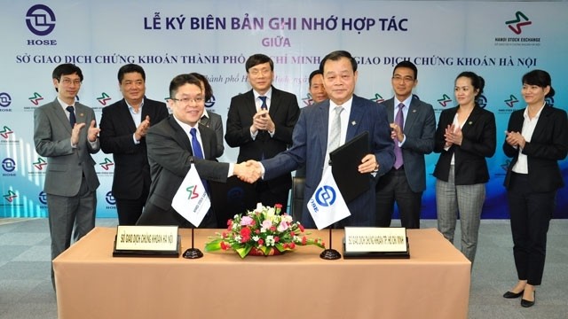 Le président du HOSE, Trân Dac Sinh (devant et à gauche), et celui de HNX, Nguyên Thành Long (devant et à droite) lors de la cérémonie de signature. Photo: NDEL.