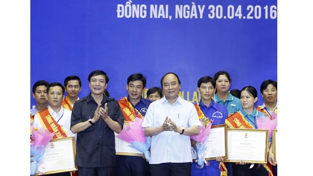 Le PM Nguyên Xuân Phuc (au centre) remet des cadeaux aux ouvriers exemplaires et meritants. Photo: NDEL.