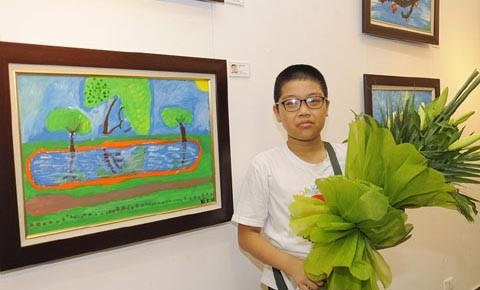 Ngô Minh Kiên, 11 ans, à côté de sa peinture "Le parc" . Photo : Nhân Dân