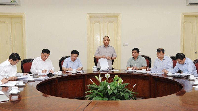 Le PM vietnamien, Nguyên Xuân Phuc (debout), lors de la réunion avec certains ministères et services sur la situation macroéconomique. Photo: Trân Hai/NDEL.